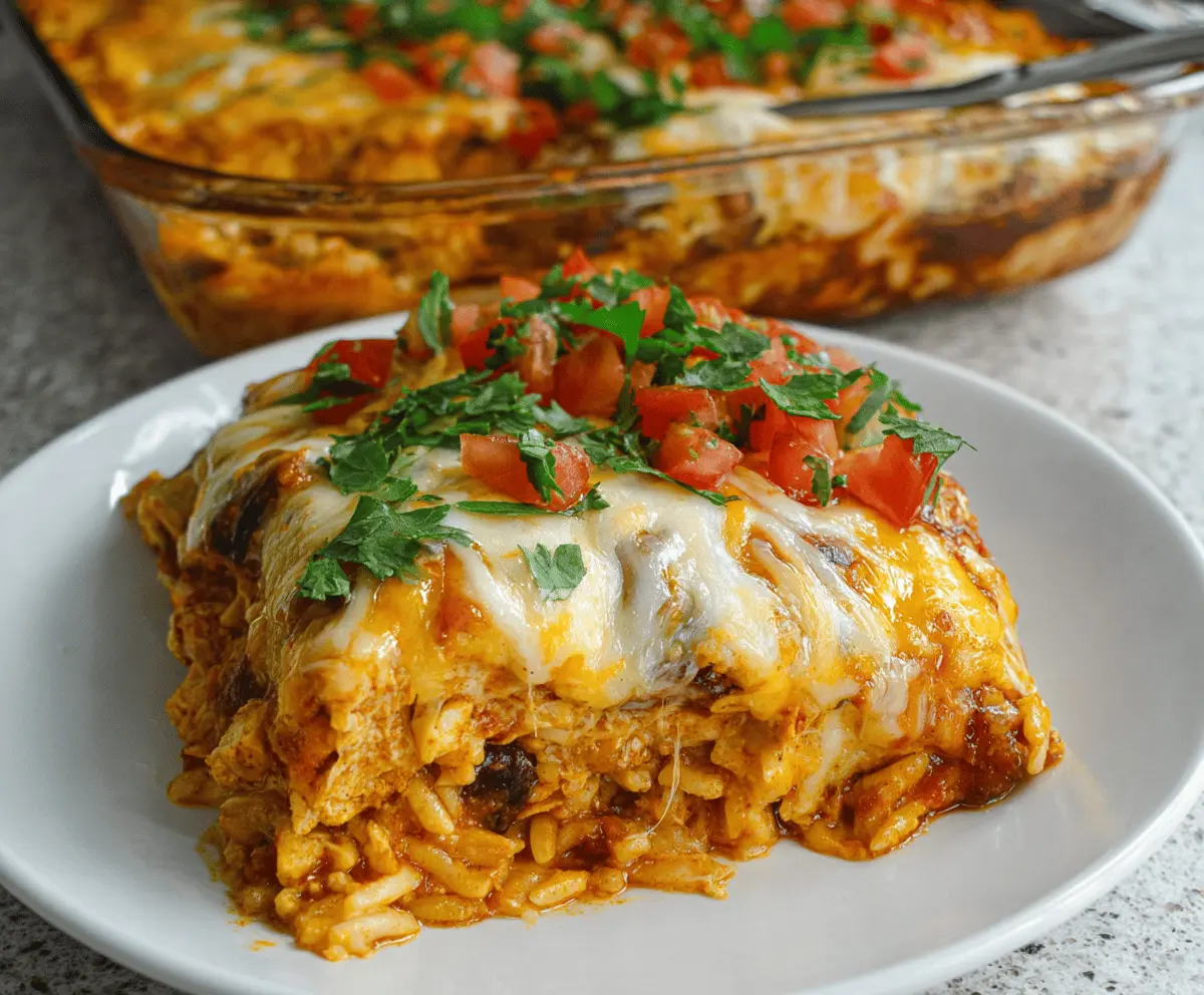 Delicious Chicken Burrito Casserole topped with melted cheese, fresh cilantro, and diced tomatoes in a baking dish