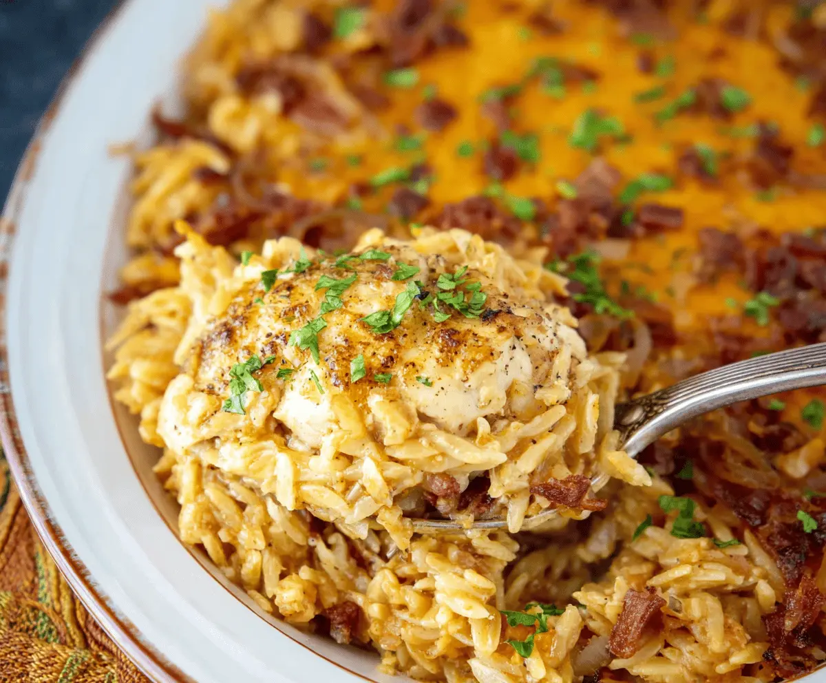 Creamy French Onion Chicken Orzo Casserole topped with melted cheese and caramelized onions, served in a baking dish.