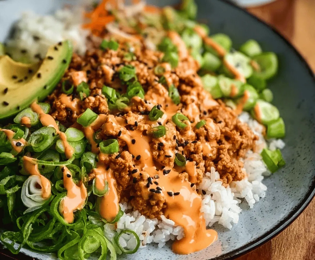 Delicious ground turkey rice bowl topped with vibrant Bang Bang sauce, served in a modern dish.