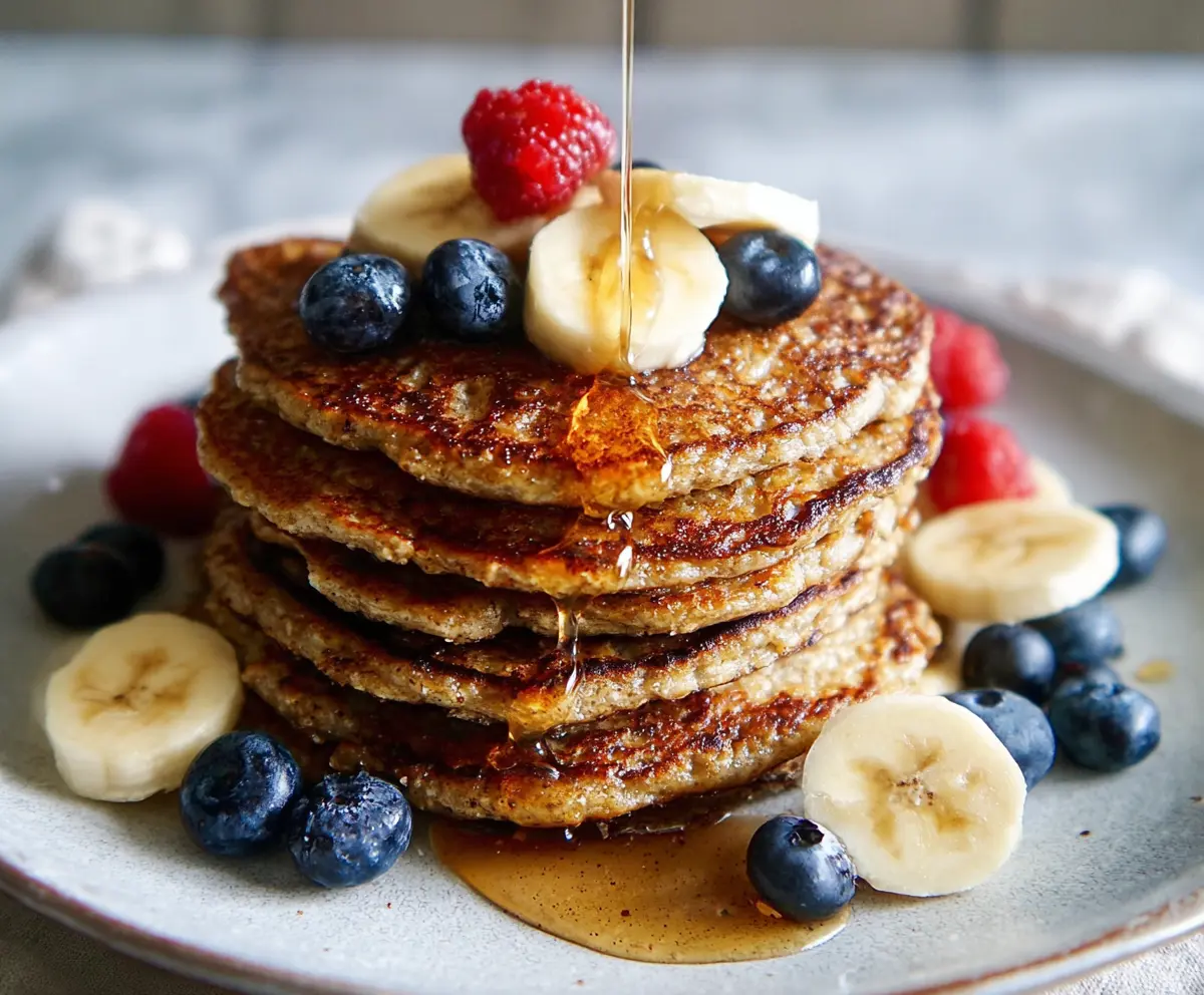 Delicious 3 Ingredient Banana Oatmeal Pancakes topped with fresh fruits on a breakfast plate