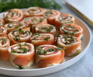 Delicious smoked salmon pinwheels served as easy party appetizers on a platter.
