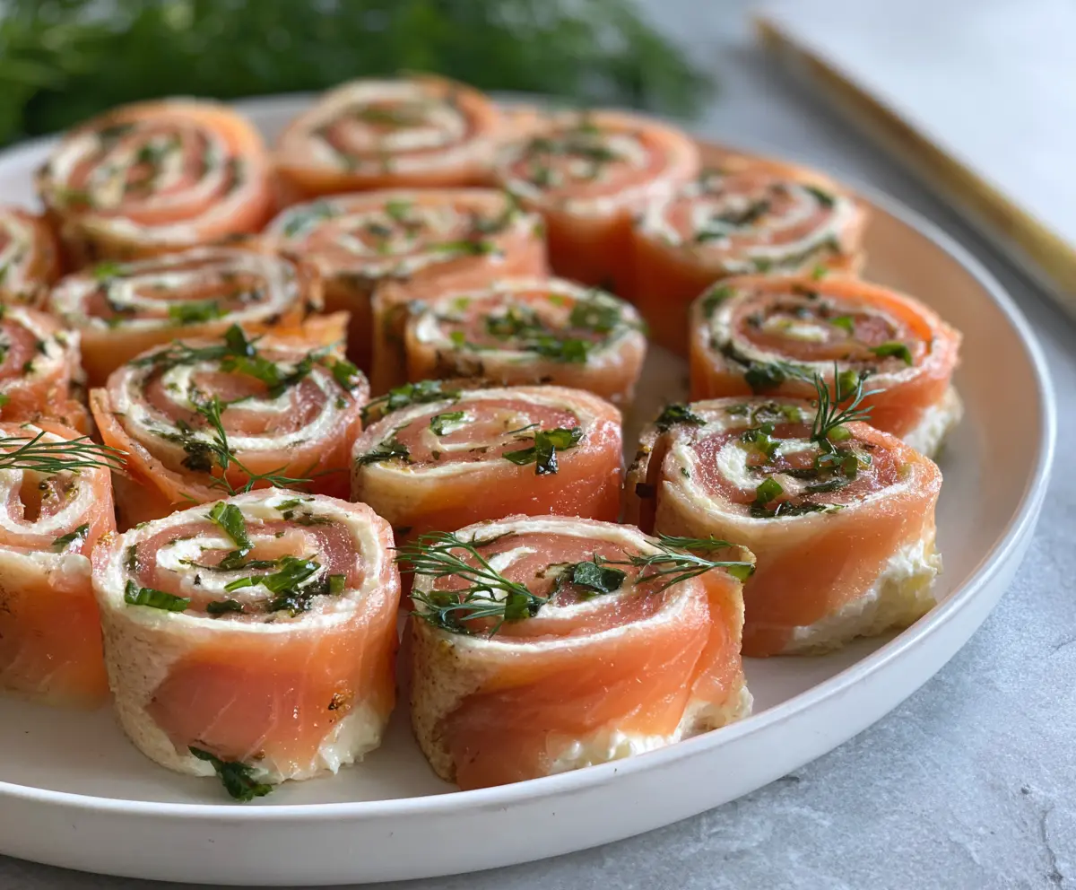Delicious smoked salmon pinwheels served as easy party appetizers on a platter.